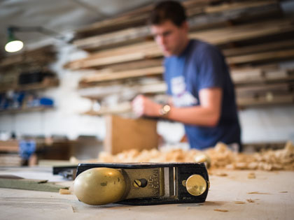 woodworking course student planing