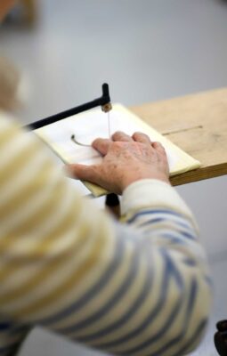 A photo from the Marquetry Course at Farnham School of Furniture Making. It shows a course pupil cutting detailed marquetry.