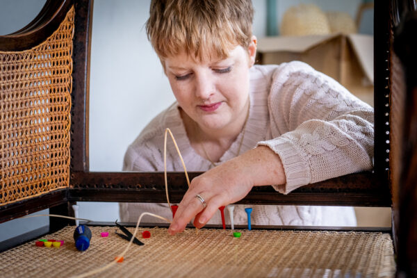 A photo from the chair caning course at Farnham School of Furniture. It shows a chair being caned by hand.